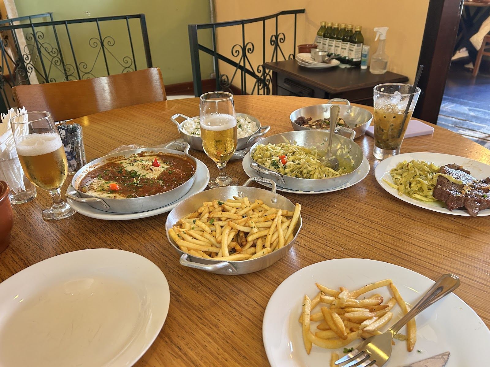 Mesa cheia com pratos, batata frita e cerveja